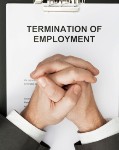 man with clasped hands over termination of employment document